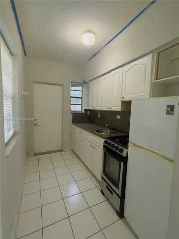 a kitchen with a stove a refrigerator and a sink