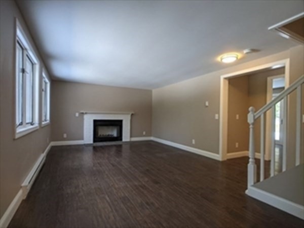 77 Algerie Road Becket, MA 01223 - Photo 3 of 20 an empty room with wooden floor and fireplace