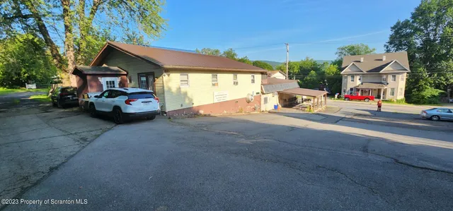 a room with lots of white furniture and a chandelier