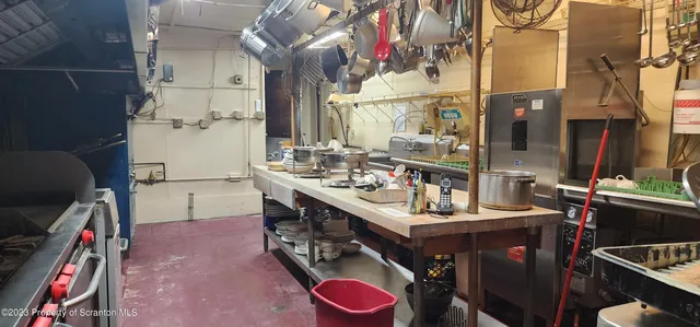 a room with lots of wooden furniture a rug and a chandelier