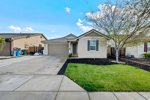 a front view of a house with a yard and trees