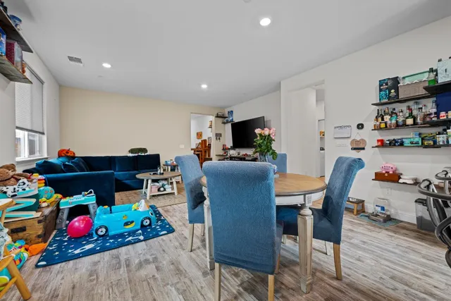 a large kitchen with stainless steel appliances a stove a sink a oven a table and chairs