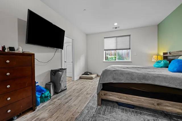 a bedroom with a bed and wooden floor