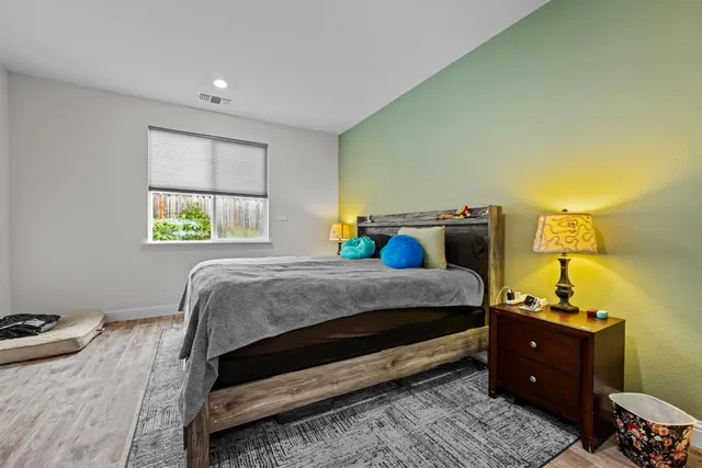 a bedroom with a bed and a potted plant on dresser
