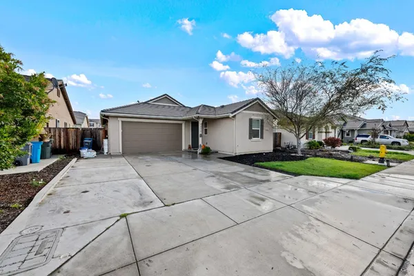a view of a house with a yard and large tree