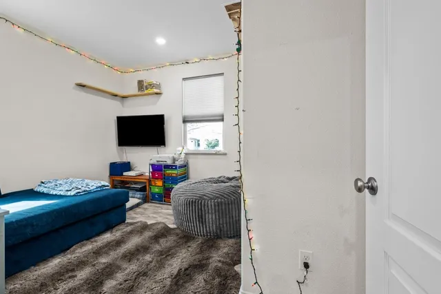 a bedroom with furniture and a flat screen tv