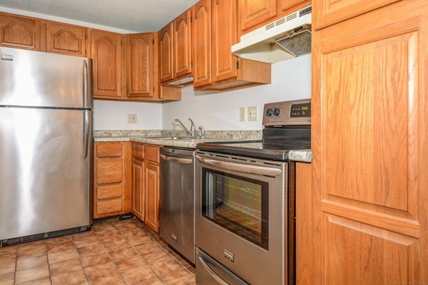 79 Leonard Road, Unit 79 Boxborough, MA 01719 - Photo 4 of 16 a kitchen with stainless steel appliances granite countertop a refrigerator a stove a sink and dishwasher