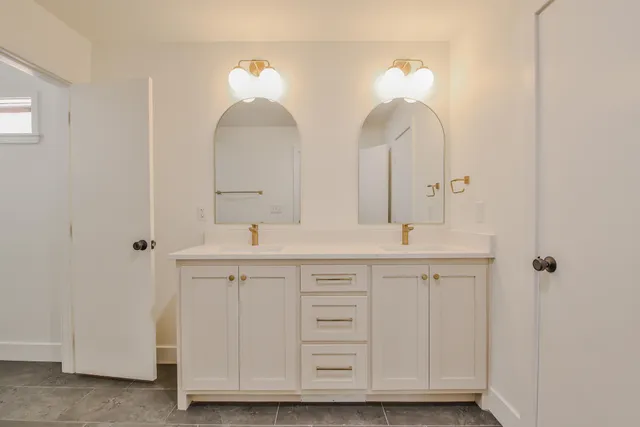 a bathroom with double sink and a mirror