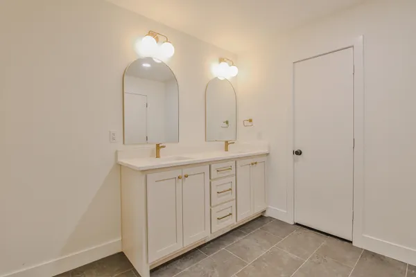 a spacious bathroom with a double vanity sink and a mirror