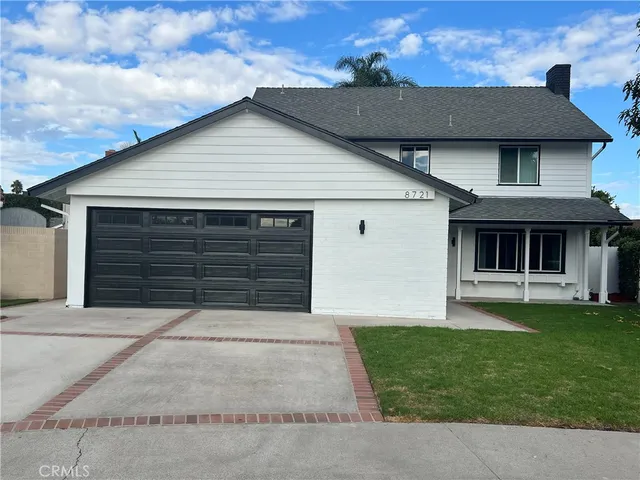 a front view of a house with a garden and yard