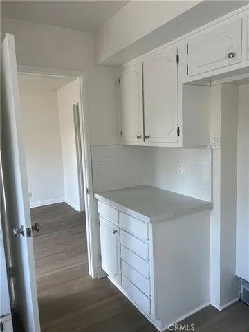 a kitchen with white cabinets and a refrigerator