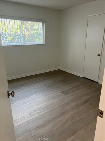 an empty room with wooden floor and closet
