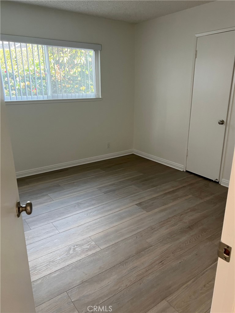 8721 Squires Circle Huntington Beach, CA 92646 - Photo 13 of 43 an empty room with wooden floor and windows