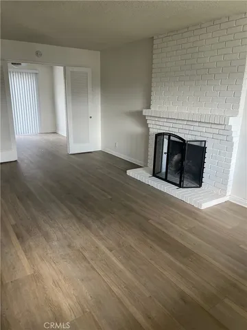 an empty room with wooden floor and fireplace