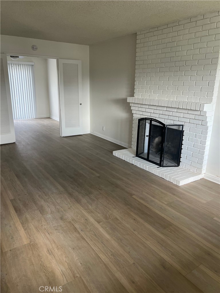 8721 Squires Circle Huntington Beach, CA 92646 - Photo 3 of 43 an empty room with wooden floor and fireplace