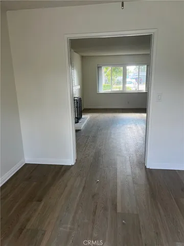 an empty room with wooden floor and a window