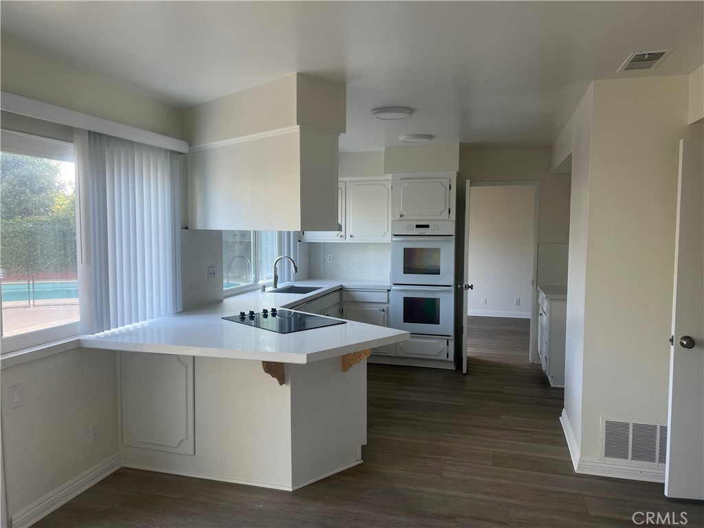 8721 Squires Circle Huntington Beach, CA 92646 - Photo 9 of 43 a kitchen with stainless steel appliances granite countertop a stove and a refrigerator