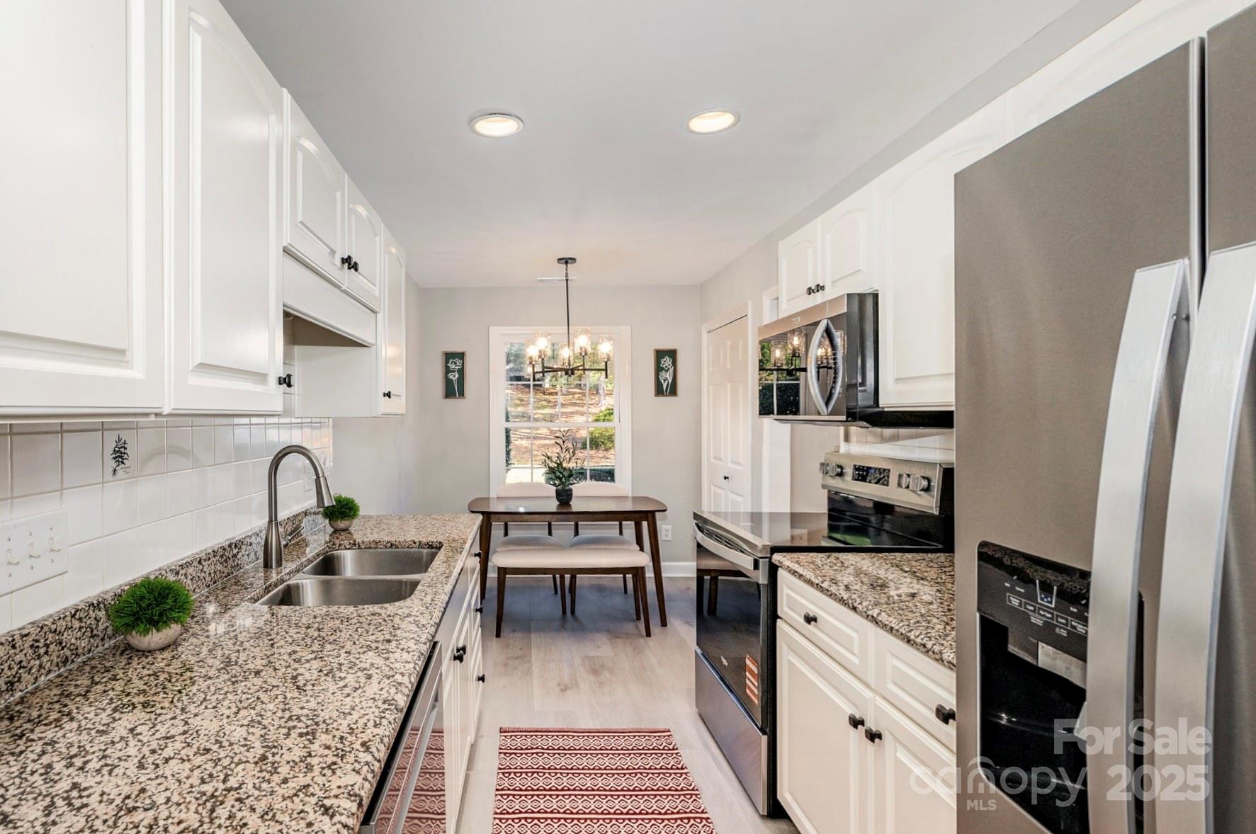 7047 Quail Hill Road Charlotte, NC 28210 - Photo 12 of 29 a kitchen with stainless steel appliances granite countertop a sink stove refrigerator and cabinets