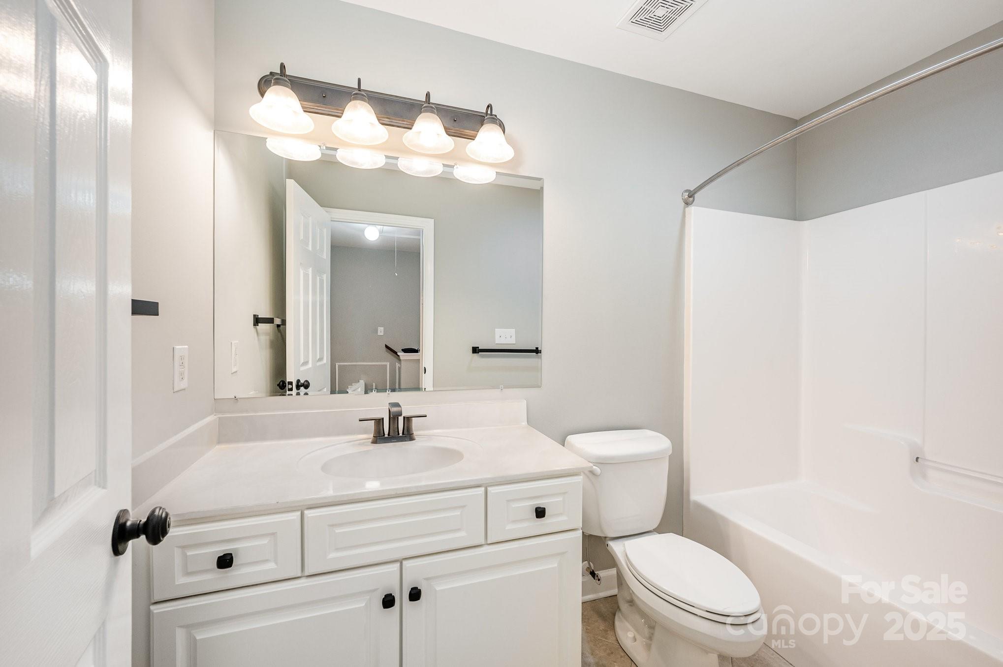 7047 Quail Hill Road Charlotte, NC 28210 - Photo 23 of 29 a bathroom with a sink a toilet and a mirror