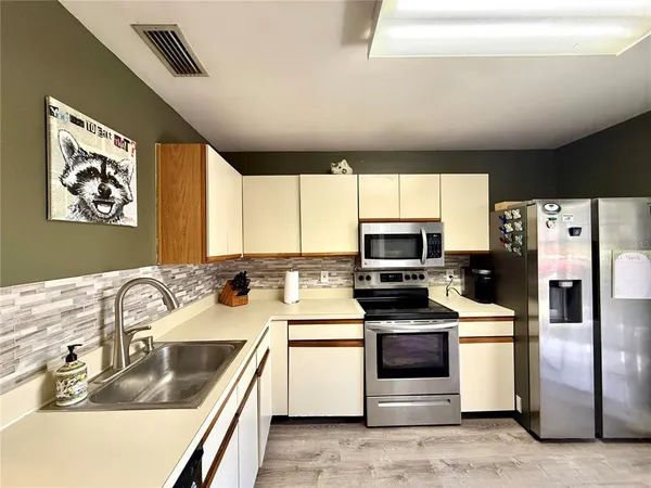 a kitchen with stainless steel appliances a stove a sink and a microwave
