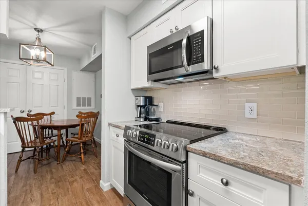 a kitchen with stainless steel appliances granite countertop a stove microwave and cabinets
