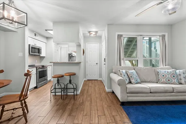a living room with furniture and a wooden floor