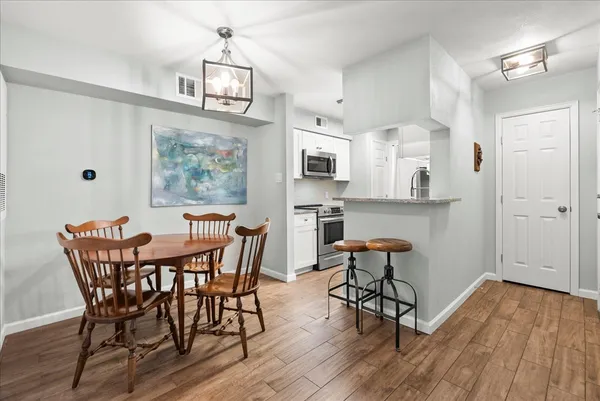 a view of a dining room with furniture wooden floor and chandelier
