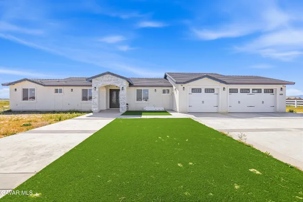 a view of house with yard and car parked