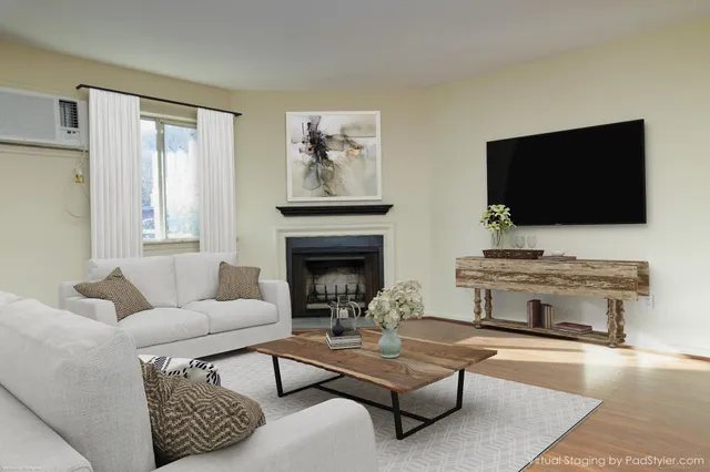 a living room with furniture a flat screen tv and a fireplace