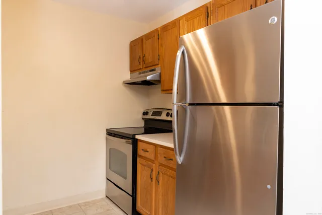 a view of a refrigerator in kitchen and a window