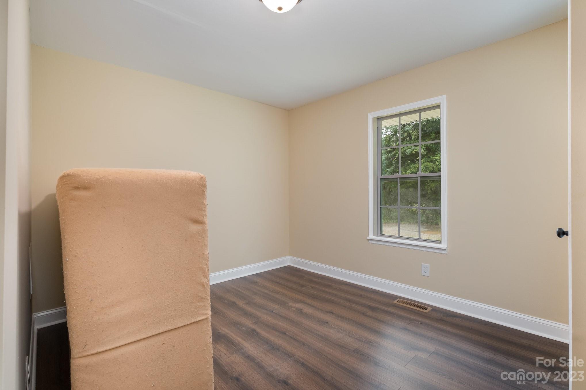 260 Upper Stanley Road Stanley, NC 28164 - Photo 12 of 18 a view of an empty room with wooden floor and a window