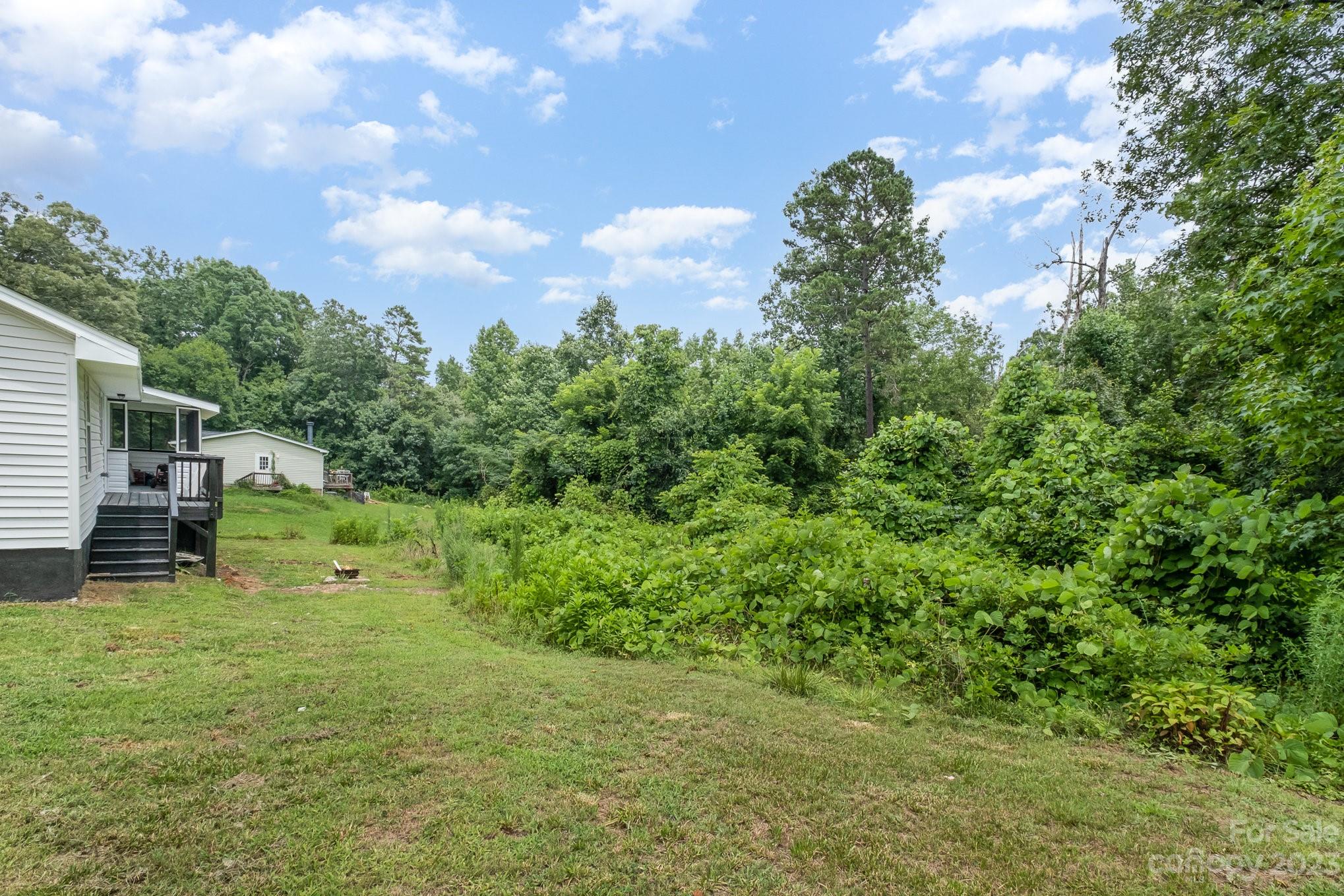 260 Upper Stanley Road Stanley, NC 28164 - Photo 15 of 18 a backyard of a house with plants and large tree