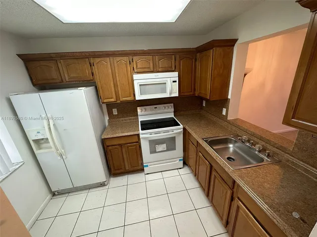 a kitchen with a stove a sink and a refrigerator