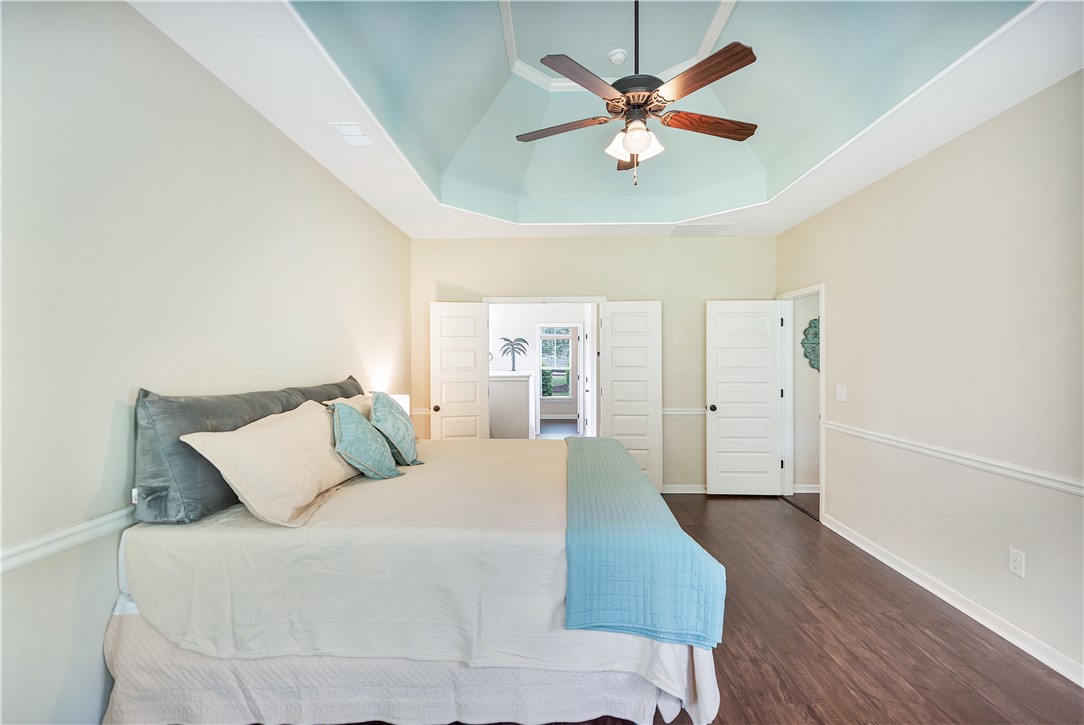 144 Buckland Drive Anderson, SC 29621 - Photo 5 of 48 A tray ceiling and rich wood flooring enhance this primary bedroom's airy atmosphere.