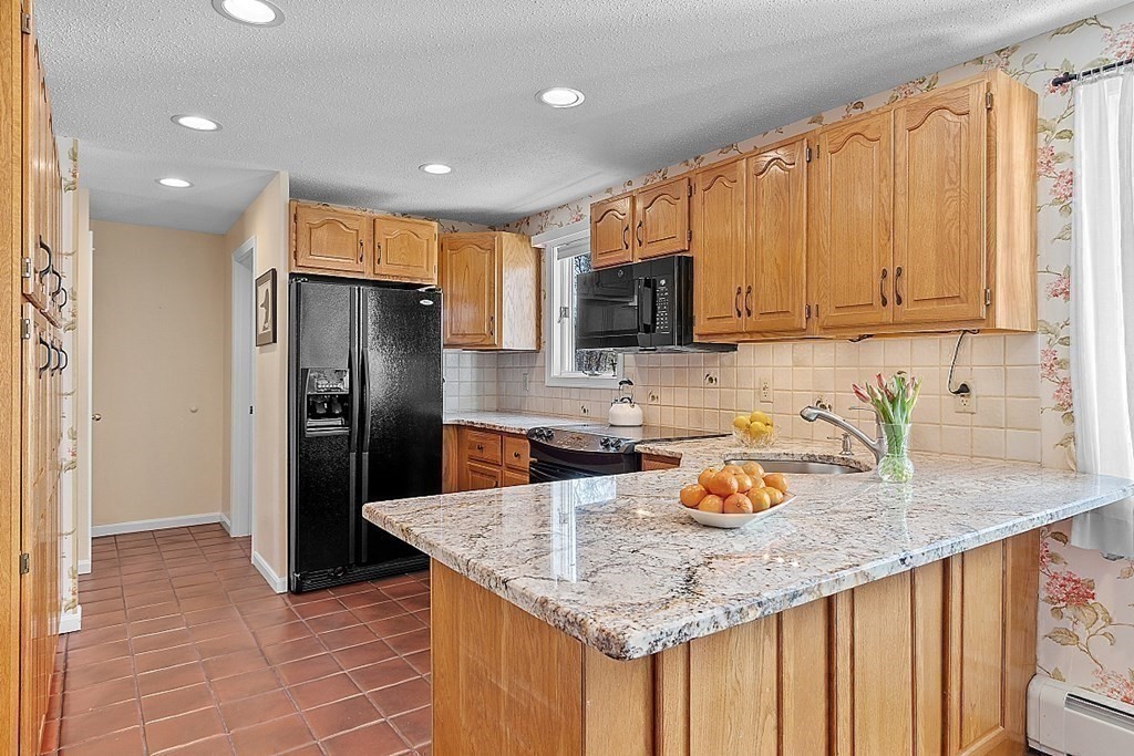 25 Strawberry Hill Road Andover, MA 01810 - Photo 17 of 38 a kitchen with granite countertop kitchen island a sink appliances and cabinets