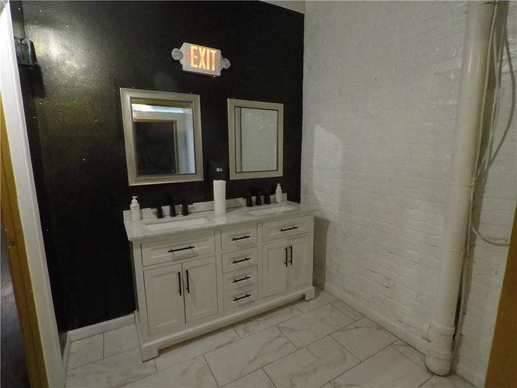 251 Trinity Avenue Southwest Atlanta, GA 30303 - Photo 11 of 32 a bathroom with a double vanity sink and a mirror