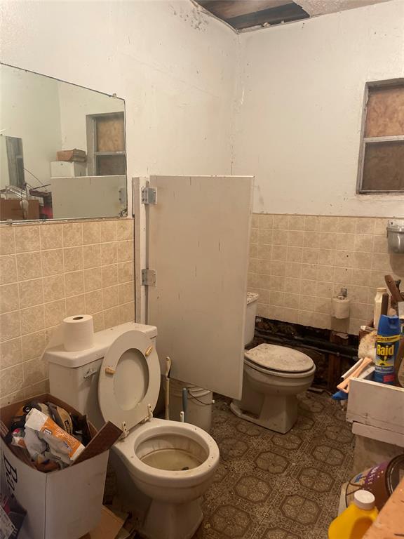 2819 Village Creek Road Fort Worth, TX 76105 - Photo 11 of 11 a white toilet sitting next to a bathroom sink and a mirror