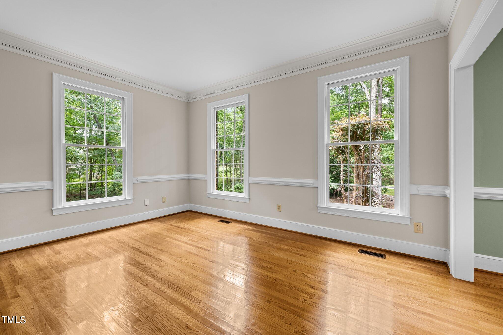 8413 Bournemouth Drive Raleigh, NC 27615 - Photo 33 of 94 a view of an empty room with a window and wooden floor