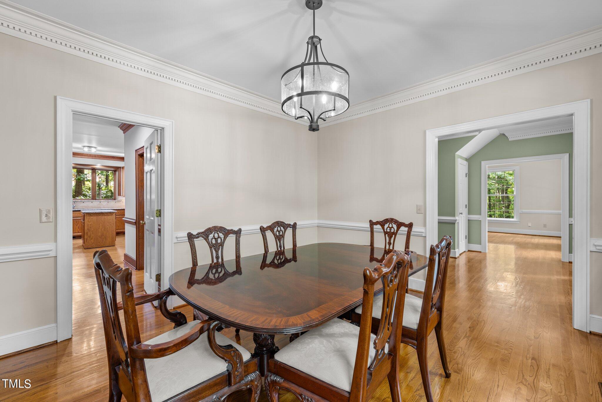 8413 Bournemouth Drive Raleigh, NC 27615 - Photo 37 of 94 a view of a dining room with furniture wooden floor and a chandelier