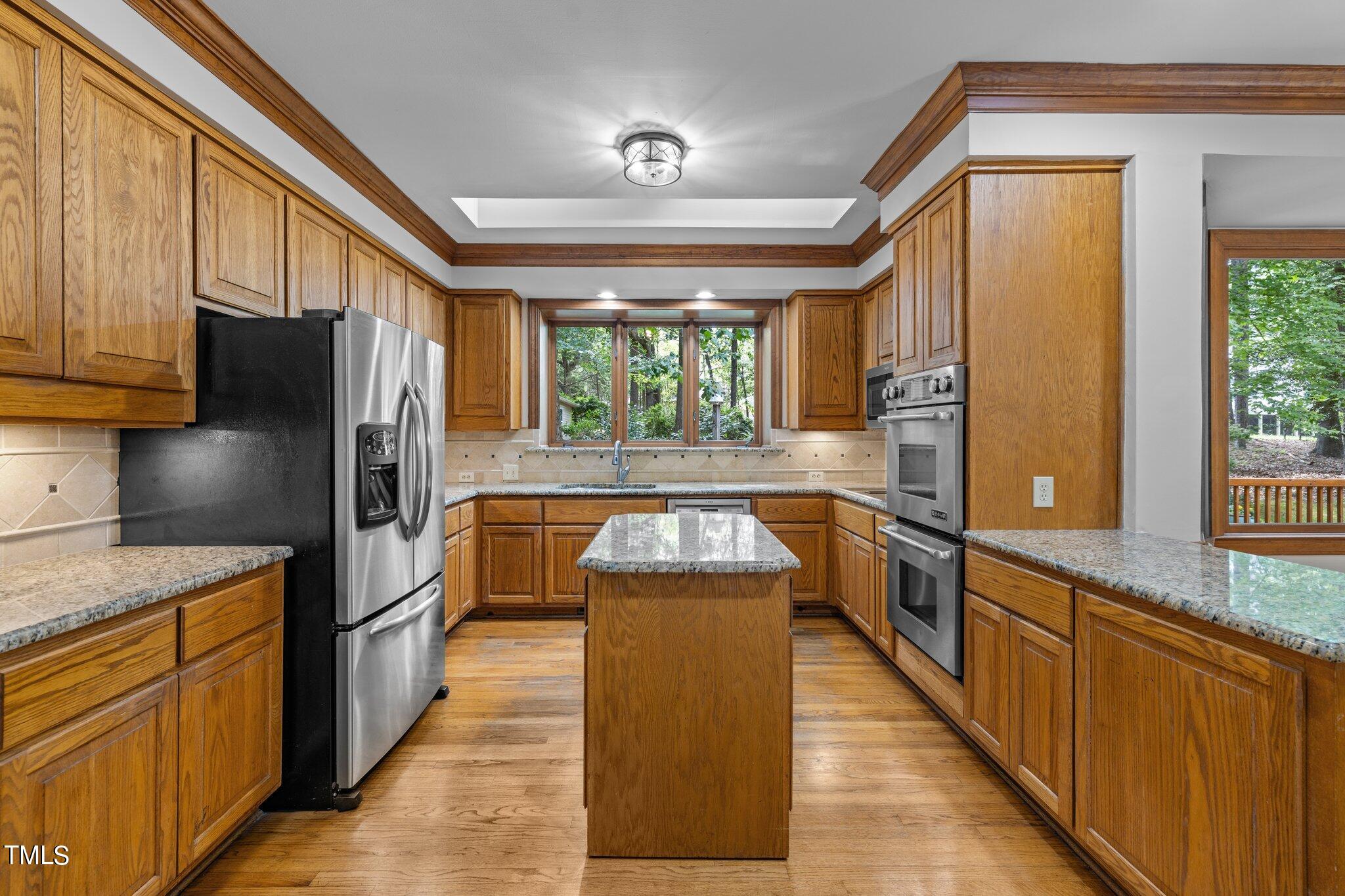 8413 Bournemouth Drive Raleigh, NC 27615 - Photo 49 of 94 a kitchen with stainless steel appliances granite countertop a refrigerator a stove and a sink