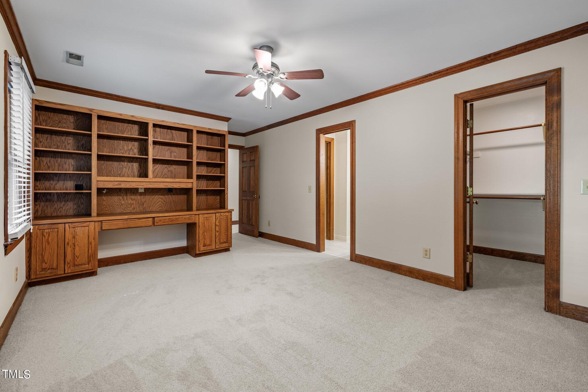 8413 Bournemouth Drive Raleigh, NC 27615 - Photo 70 of 94 a view of an empty room with a cabinet and a ceiling fan