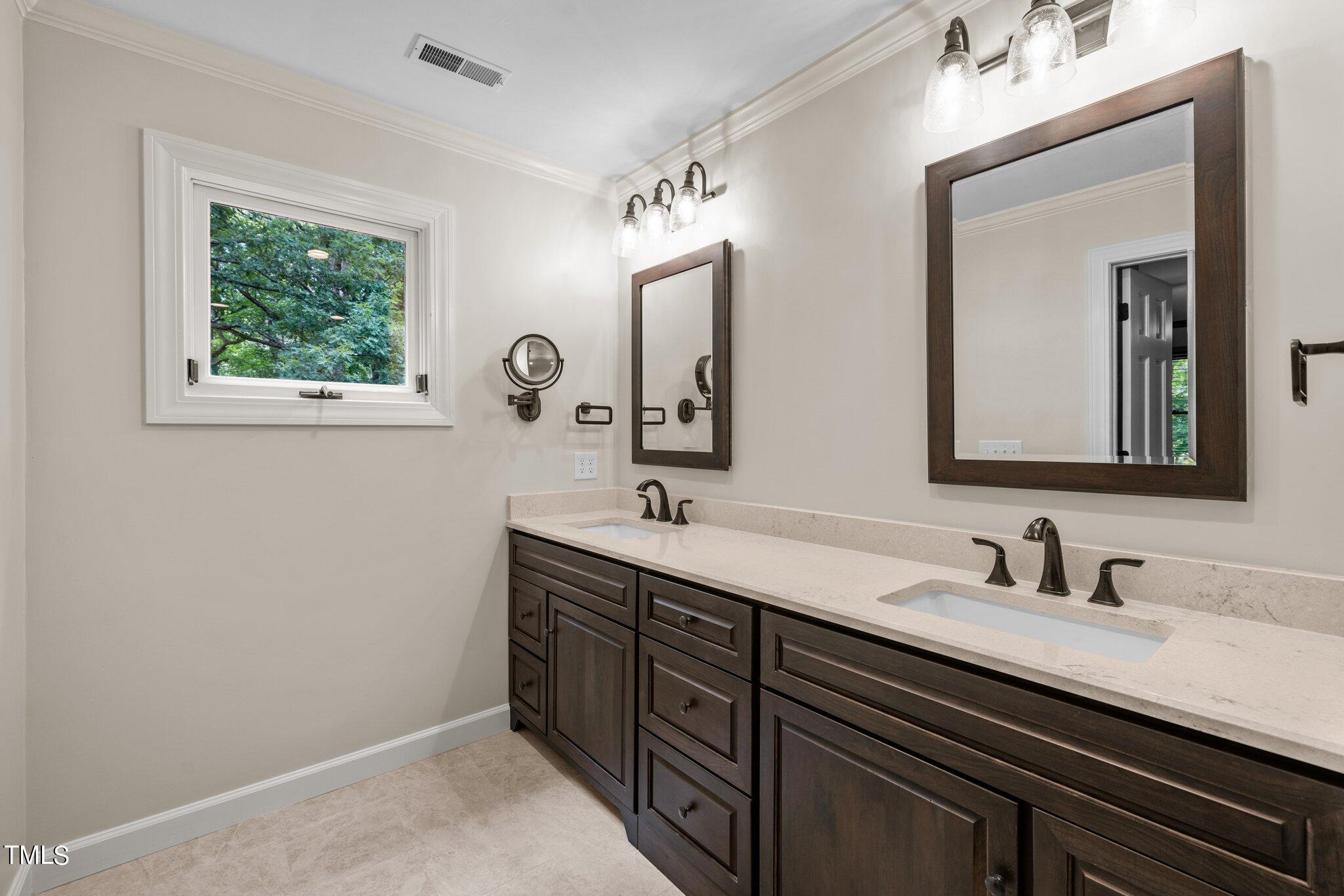 8413 Bournemouth Drive Raleigh, NC 27615 - Photo 77 of 94 a bathroom with a double vanity sink and a mirror