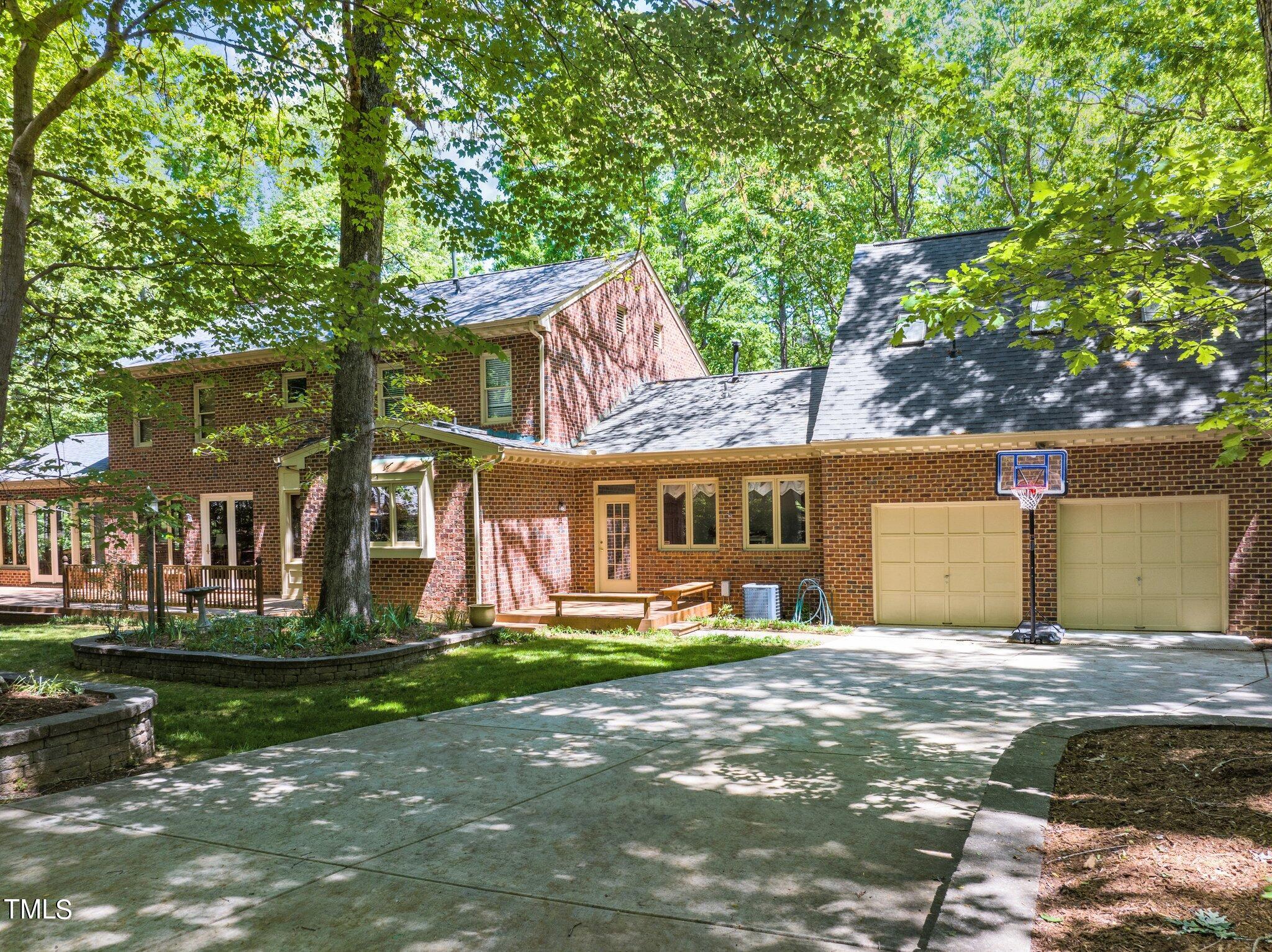 8413 Bournemouth Drive Raleigh, NC 27615 - Photo 10 of 94 a front view of a house with a garden and trees