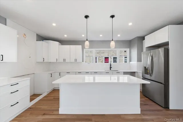 a large kitchen with stainless steel appliances granite countertop a lot of counter space and wooden floors