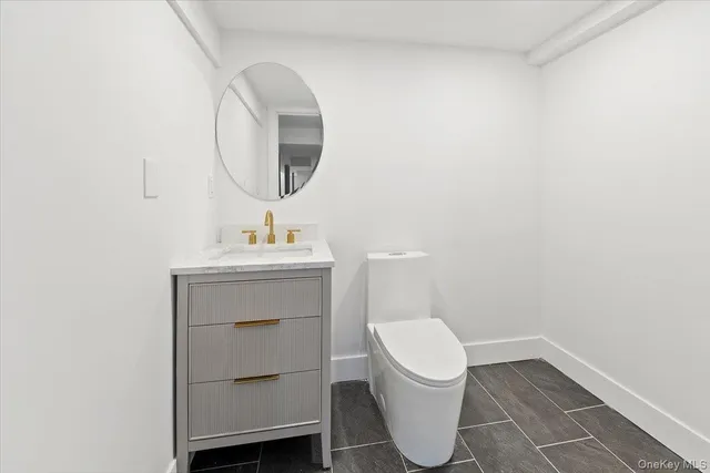a bathroom with a toilet sink and mirror