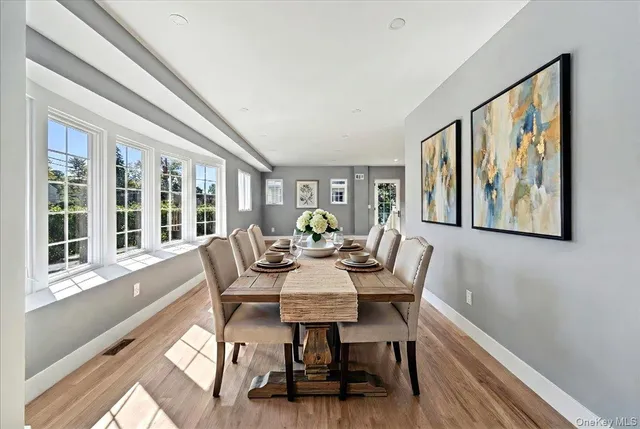 a view of a dining room with furniture a rug and wooden floor