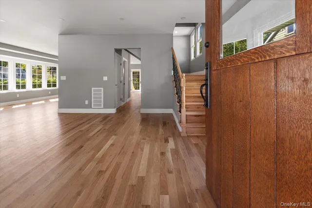 a view of a hallway with wooden floor and staircase
