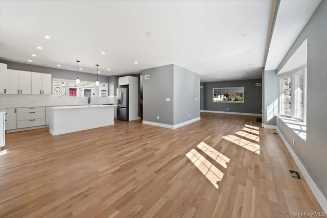 a view of entryway and kitchen with wooden floor