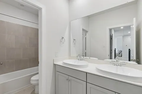 a bathroom with a double vanity sink toilet and shower