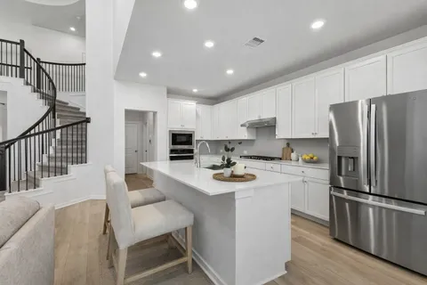 a kitchen with refrigerator and chairs